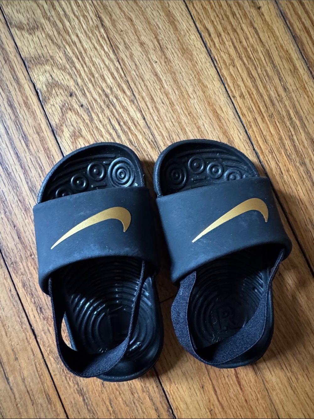 Nike Black Slides with Gold Swoosh Accent